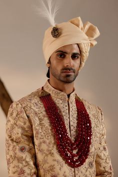 a man wearing a turban and beaded necklace