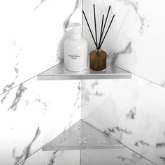 a bathroom shelf with two bottles and some reeds on it