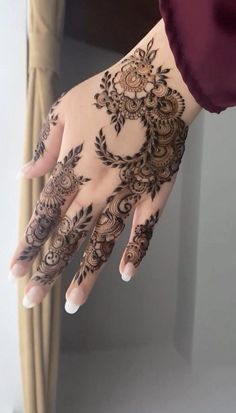 a woman's hand with henna tattoos on it