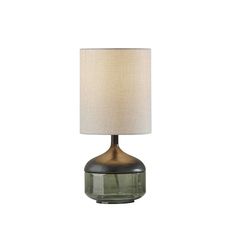 a glass table lamp with a beige shade