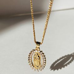 We celebrate the goodness of Mother Mary in big and small ways. The Empowered Mother Mary Necklace is a sentimental and stylish statement necklace. Featuring her beautiful CZ design and the strength she possesses all in one necklace. Product Details: 18" 14k Gold-Filled Baby Curb Chain 30mm CZ Mother Mary Charm Not Water-Wearable Made in Scottsdale, AZ Cubic Zirconia Medallion Necklace Gift, Gold Diamond Pendant Necklace With Halo, Spiritual Gold Plated Necklace For Anniversary, Anniversary Gold Plated Necklace, Spiritual Gold Necklace For Mother's Day, Gold Cubic Zirconia Medallion Necklace, Spiritual 14k Gold Necklace For Mother's Day, Spiritual Gold Halo Jewelry, 14k Gold Pendant Necklace With Halo