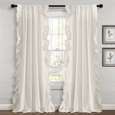 white curtains with ruffled edges hanging in front of a wooden floor and window sill