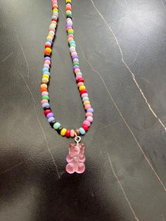 Handmade gummy bear necklace. Multicolored seed beads and a pink gummy bear charm.  length: 20 inches  closure: lobster clasp  charm: pink gummy bear  Please feel free to reach out to me with any questions or to discuss a custom order. Playful Pink Charm Necklace For Friendship, Playful Pink Charm Necklaces For Friendship, Handmade Sweet Jewelry With Beads, Cute Beaded Necklaces With Tiny Beads For Gifts, Cute Beaded Necklaces With Tiny Beads As Gifts, Cute Beaded Necklace With Tiny Beads For Gifts, Cute Pink Necklaces With Tiny Beads, Cute Pink Beaded Chain Necklaces, Cute Pink Beaded Chain Necklace