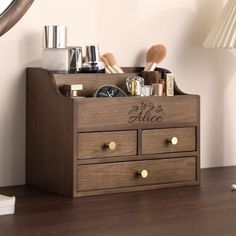 a wooden dresser with personalized items on it and a mirror in the corner behind it