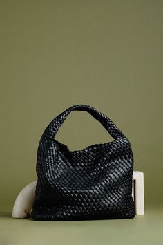 The black shoulder bag is a stylish, functional accessory. Crafted with vegan leather and a unique woven design, The Melie Bianco handbag offers a reliable choice for those seeing a timeless, fashionable look. The spacious interior of the shoulder bag is perfect for carrying all your essentials. Recycled Vegan Leather 15"W x 13"H x 5"D Handle Drop: 7.5" Magnetic Closure Removable Zip Pouch Unlined Fits up to an iPad Woven Leather Satchel For On-the-go, Black Woven Leather Hobo Bag For On-the-go, Modern Satchel With Intrecciato Weave For Daily Use, Modern Bags With Intrecciato Weave For Errands, Modern Intrecciato Weave Bag For Errands, Modern Bags With Intrecciato Weave For Everyday Use, Modern Woven Leather Shoulder Satchel, Modern Intrecciato Bag For Everyday, Modern Woven Leather Crossbody Bag