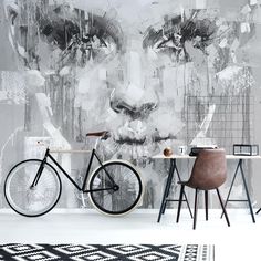 a bicycle is parked in front of a wall with an artistic painting on it's side