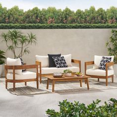 an outdoor living room with white furniture and potted plants