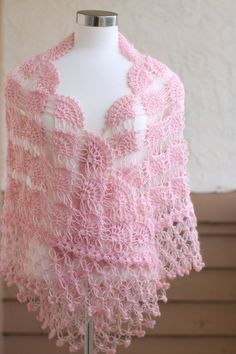 a pink crocheted shawl on a mannequin