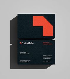 two black business cards with an orange arrow on the front and back, both printed in red