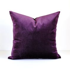 a purple pillow sitting on top of a white table