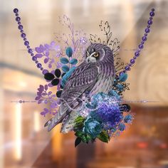 an owl sitting on top of a bouquet of flowers next to a beaded necklace