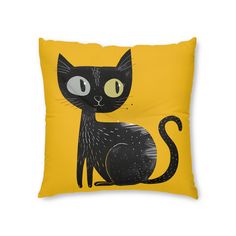 a yellow pillow with a black cat on it