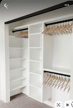 an empty closet with white shelves and wooden hangers