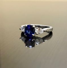 "DeKara Designs Collection Beautiful Modern/Art Deco Ceylon Blue Sapphire and Diamond Ring Metal- 90% Platinum, 10% Iridium Stones- Natural Oval Ceylon Blue Sapphire 1.34 Carats, 2 Trillion Cut Diamonds, F-G Color VS1 Clarity, 0.52 Carats. Size-6 1/4 Plus. FREE SIZING Classic and Timeless Art Deco Inspired Ceylon Blue Sapphire Oval Diamond Engagement Ring. The center sapphire is a beautiful deep blue in color, and is \"Eagle Claw\" prong set to perfection, with two Trillion Cut Diamonds that are Classic Trillion Cut Sapphire Ring, Classic Sapphire Jewelry Gia Certified, Classic Gia Certified Sapphire Jewelry, Classic Trillion Cut Sapphire Jewelry, Classic Trillion Cut Brilliant Sapphire Ring, Classic Sapphire Ring With Trillion Brilliant Cut, Classic Sapphire Marquise Cut Ring, Classic Sapphire Ring With Marquise Cut, Trillion Cut Platinum Gemstone Rings