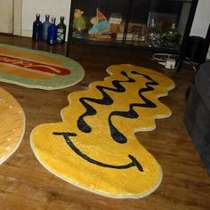 three rugs with smiley faces on them in the middle of a living room floor