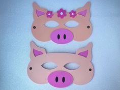 two pink pigs with flowers on their ears and nose cut out to look like they are wearing masks