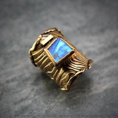 Modern, Brutalist-style Textured Ring. Fully handmade work. 18Ct Gold Plated Bronze. Oxidized. The ring is covered with a protective layer. The main accent of this ring is a natural Rainbow Moonstone. Material: 18Ct Gold Plated Bronze, Rainbow Moonstone. The height of the central part is 3.3 cm. Size: Adjustable. Color: Blue, Antique Gold Unique Yellow Gold Moonstone Ring, Hand Forged Gold Moonstone Rings, Gold Hallmarked Moonstone Rings, Gold Moonstone Hallmarked Rings, Hand Forged Moonstone Jewelry In Yellow Gold, Handmade Fine Jewelry Yellow Gold Moonstone Ring, Handmade Yellow Gold Moonstone Ring Fine Jewelry, Yellow Gold Moonstone Jewelry, Handmade Yellow Gold Moonstone Ring