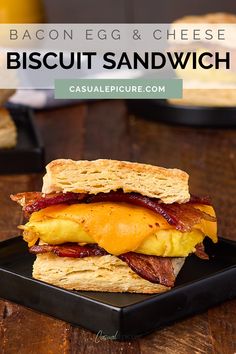 bacon egg and cheese biscuit sandwich on a black plate with text overlay that reads bacon egg and cheese biscuit sandwich