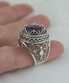 This 925 Sterling silver filigree art women dome ring comes with faceted amethyst gemstone. This piece of art sterling silver cocktail ring will all attracts you.    Gorgeous Embroidery Filigree Design - This beauty features a design showcasing gorgeous rose-cut 12 mm amethyst stone, center stone on a round setting with a filigree setting all around it. Elegant Sterling Silver - This ring is made from 100% 925 sterling silver which is both stunning and durable. This ring is made with an exquisite filigree pattern which has been oxidized and highly polished. Engraved Design - This ring's elegant design includes engraved detailing which surrounds the gemstone. This is a gorgeous cocktail ring set in 925 Sterling Silver. The ring has filigree lace detailing on it which makes it perfect for fo Silver Filigree Amethyst Ring, Silver Sterling Silver Amethyst Ring With Filigree, Silver Filigree Amethyst Ring In Sterling Silver, Silver Amethyst Ring With Intricate Design, Ornate Sterling Silver Amethyst Gemstone Ring, Oval Sterling Silver Filigree Amethyst Ring, Ornate Sterling Silver Amethyst Ring, Ornate Sterling Silver Amethyst Ring For Anniversary, Oval Sterling Silver Amethyst Ring With Intricate Design