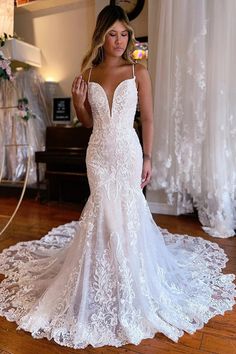 a woman in a white wedding dress standing on a wooden floor