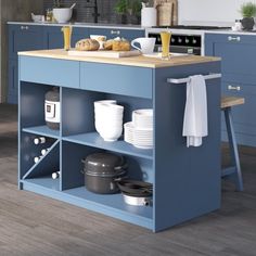 a blue kitchen island with plates and cups on it