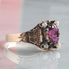 Details: Beautiful Victorian Garnet and Seed Pearl ring set in lovely 14K rose gold. The band is adorned in lovely abstract filigree engraving. The stone has great depth, and has a lovely rich pink tint to the garnet. It is surrounded by 4 seed pearls. The garnet measures 7.5mm x 5mm. There are no internal markings. Measurements: Ring measures a size 7 3/4 US. It can be re-sized for a fee. Condition: The overall all condition of this ring is very good. Please ask all questions prior to placing a Pink Ruby Ring In 14k Rose Gold, Antique Pink Rose Cut Diamond Rings, Victorian Style Engraved 14k Rose Gold Ring, Pink Fine Jewelry Birthstone Ring For Formal Occasions, Classic Pink Amethyst Wedding Ring, Pink Birthstone Ring For Formal Occasions, Pink Hallmarked Victorian Ruby Ring, Victorian Pink Hallmarked Ruby Ring, Vintage Pink Ruby Ring In 14k Gold