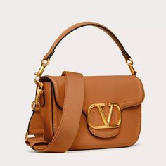 Expertly crafted from soft grainy calfskin leather, the Valentino Garavani Alltime shoulder bag exudes elegance and sophistication. Its versatile design allows you to wear it on your shoulder, cross-body or handheld, offering convenience and style in one. Complete with a metallic VLogo Signature detail, this bag is a must-have for any fashion-forward individual. Leather Satchel Baguette Bag With Branded Hardware, Leather Baguette Bag With Branded Hardware And Double Handle, Luxury Baguette Bag With Branded Hardware For Daily Use, Luxury Textured Leather Satchel Baguette Bag, Everyday Luxury Textured Leather Shoulder Bag, Leather Baguette Shoulder Bag With Branded Hardware, Luxury Textured Leather Top Handle Baguette Bag, Leather Baguette Bag With Branded Hardware, Luxury Textured Leather Baguette Bag For Formal Occasions