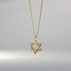 Fall in love with its captivating symmetry. This 14K solid gold handmade star of David pendant is a must-have for anyone who pays attention to even the smallest of details. A quick inspection of the piece will make you admire over the 30 years of experience we bring with every handcrafted pendant we make. This one is no exception as the edges, the points, and its overall appeal genuinely captures the aura of one of the most popular Jewish symbols. Send it as a gift or add it to your collection o Yellow Gold Star Charm Necklace For Anniversary, Engraved Star-shaped Yellow Gold Necklace, Classic Star Of David Jewelry For Gift, Classic Star Of David Jewelry For Anniversary, Spiritual Yellow Gold Necklace With Star Charm, Gold Engraved Star Of David Necklace, Engraved Yellow Gold Star Of David Jewelry, Classic Star Shaped Necklace For Gift, Classic Star-shaped Necklace As Gift