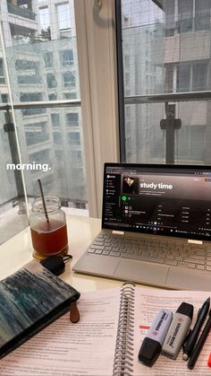 an open laptop computer sitting on top of a desk next to a cup of coffee