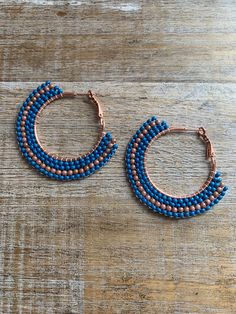 Large copper tone hoops with added glass beads. They are a blue color with a strip of tan/beige beads. They measure 2 inches long.  Hand beaded by me! Brick Stitch Hoop Earrings, Hoop Earrings Large, Large Hoop Earrings, Earrings Blue, Brick Stitch, Copper Earrings, Glass Crystal, Jewelry Earrings Hoops, Blue Beads