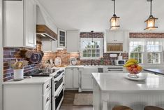 a kitchen with brick walls and white cabinets