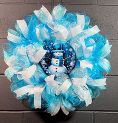 a blue and white wreath with a snowman on it