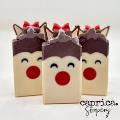 three pieces of chocolate covered with frosting and decorated like reindeers, one has red noses