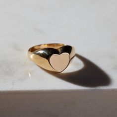 The timeless Girlfriend Signet Ring combines classic sophistication with playful spirit. The curved thick band is molded to a statement heart shape, which offers a refined aesthetic sure to be admired. The 18-karat gold filled ring is electroplate finished to provide a luxe and long-lasting finish, able to withstand water and more! Classic Oval Heart Ring For Valentine's Day, Classic 14k Gold Heart-shaped Signet Ring, Classic Heart Shaped 14k Gold Signet Ring, Classic Heart-shaped 14k Gold Signet Ring, Classic Heart Ring With Polished Finish, Classic Gold Heart Signet Ring, Classic Heart-shaped Rings With Heart Charm, Classic Heart Cut Rings With Heart Charm, Classic Open Ring Jewelry For Valentine's Day