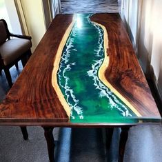 a wooden table with green and yellow paint on it, along with two chairs in the background