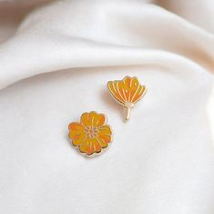 Golden Poppy earrings embody the vibrant spirit of California's state flower in a dazzling mismatched pair--one in full, bright orange bloom and the other just about to unfurl. A stunning tribute to nature's timing and beauty! Enamel earring with polished gold-plated metal, featuring stainless steel posts with 0.5" (13 mm) extra-long design for secure, stable wear, paired with silicone cone backs for a snug fit. Features 10x6mm full-cover, dust-proof studs. Details: * One pair of stud earrings (one blooming and one closing) * Polished gold-plated metal 0.5" tall * Stainless Steel Post 0.5" (13 mm) * Silicone cone backs 10x6mm full-cover Designed by @occasionalish *Please note that our stainless steel posts are sourced from a third party, and we cannot guarantee that our earrings are comple Poppy Earrings, Golden Poppy, Plant Earrings, Fleur Orange, Nickel Allergy, Earrings Flower, Enamel Earrings, Bright Orange, Flower Earrings