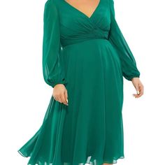 a woman wearing a green dress with long sleeves and a wrap around the neckline