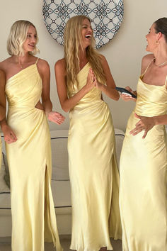 three beautiful women in yellow dresses standing next to each other