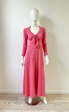 Vintage 1970s pink maxi dress with sheer back with flower detail. Buttons down the front, tie at bust, long sleeves. Label is Mikey Jrs of California. Material is poly, fits like a small. Excellent vintage condition. Please message me with any questions.  Measurements shoulder 14.5 sleeves 23 bust 34 waist 28 hip 42 length 55 more vintage clothing  https://www.etsy.com/shop/prizesforarla instagram: prizesforarla international buyers: Please note that your order may be subject to customs charges Pink Fitted Long Maxi Dress, Fitted Long Pink Maxi Dress, Fitted Pink Long Maxi Dress, Pink Full Length Maxi Dress For Spring, Pink Floor-length Maxi Dress For Fall, Spring Retro Formal Maxi Dress, Spring Formal Retro Maxi Dress, Fitted Pink Maxi Dress For Fall, Fall Pink Fitted Maxi Dress