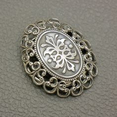 a silver brooch sitting on top of a table