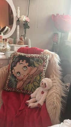 a teddy bear sitting on top of a chair next to a pillow