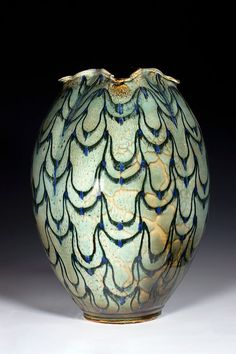 a blue and white vase sitting on top of a table next to a black background