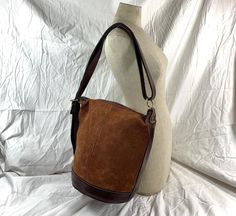 "Measurements are 12\" top wide, 11\"5 high and 9\" deep with one 35\" shoulder strap at its longest with a 10\" drop. There is one large main compartment, lined in beige fabric, back wall zipper pocket and a top zipper closure. This lovely bag is made of brown leather with tan pigskin suede, light stitching and gold tone hardware. Bag is vintage and there are light scuffs on the exterior and there are no tears. There is one exterior zipper pocket for easy to access items. ---------------------- Large Capacity Bucket Bag For Fall, Vintage Large Capacity Shoulder Bag For Fall, Retro Brown Hobo Bag Large Capacity, Brown Retro Hobo Bag With Large Capacity, Retro Brown Hobo Bag With Large Capacity, Brown Bucket Bag For Fall, Beige Leather Bucket Bag For Fall, Fall Beige Leather Bucket Bag, Leather Hobo Bag With Bucket Shape