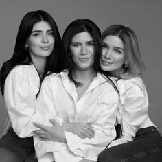 three beautiful women sitting next to each other posing for a photo in black and white