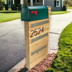 a mailbox on the side of a road in front of a house with grass