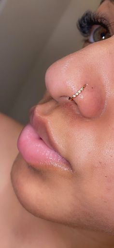 a close up of a woman's nose and nose piercing on her left side