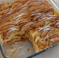 an apple pie is cut in half and ready to be eaten with powdered sugar on top