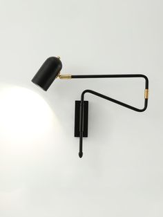 a black wall lamp with a white light on it's side and an arm that is attached to the wall