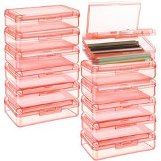 a stack of pink plastic storage containers filled with pens and pencils