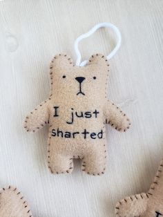 two stuffed bears are on a sheet with writing that says, i just shared and the other one has an ornament attached to it